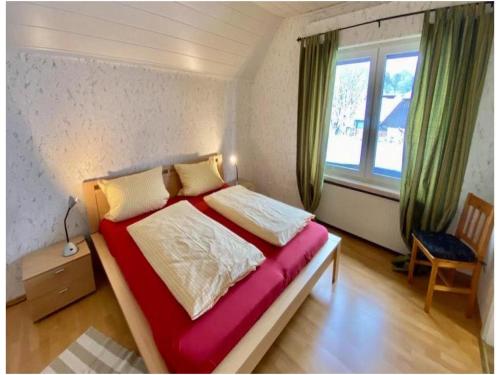 a bedroom with a large bed with a red blanket at Cafe-Restaurant Vedder in Herscheid