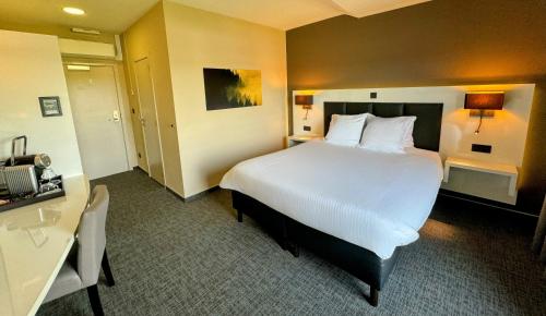 Una cama o camas en una habitación de Hôtel L'Amandier