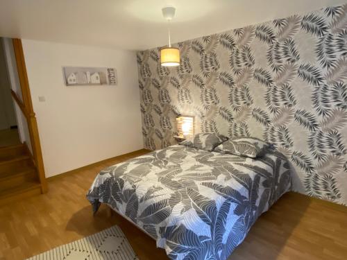 a bedroom with a bed with a patterned wall at chambres de l'étang de la Demoiselle in Saint-Nabord