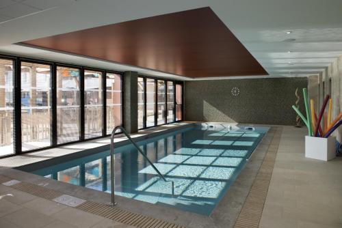 een zwembad in een gebouw met ramen bij Résidence Services Seniors DOMITYS - Villa Ulma in Lille