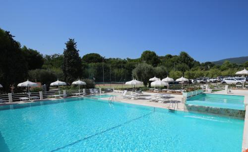 una grande piscina con sedie e ombrelloni di Green Garden Village a Sirolo