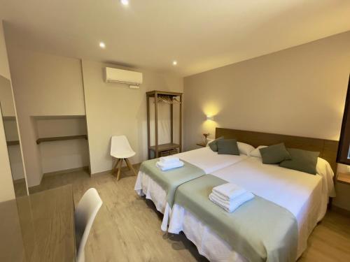 a hotel room with two beds and a chair at Casa Rural Barbarin in Barbarín