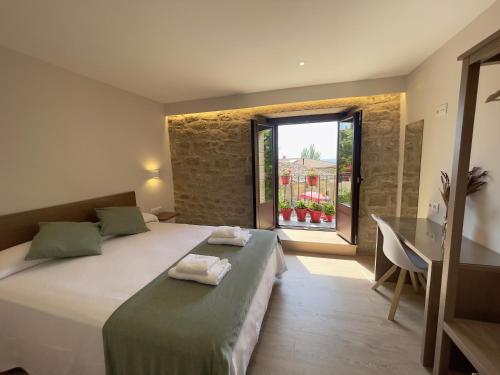 a bedroom with a bed and a desk and a window at Casa Rural Barbarin in Barbarín