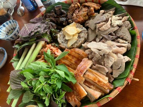 a plate of food on a wooden table at Giăng's House Farmstay & Glamping in Bao Loc