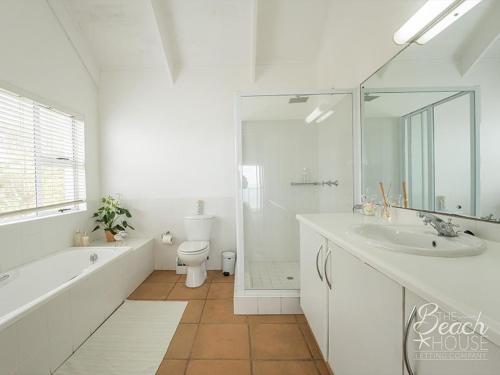 een witte badkamer met een bad, een toilet en een wastafel bij do not use this profile in Sheffield Beach