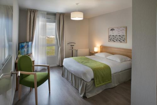 um quarto com uma cama, uma cadeira e uma janela em Résidence Services Seniors DOMITYS - Villa Ulma em Lille