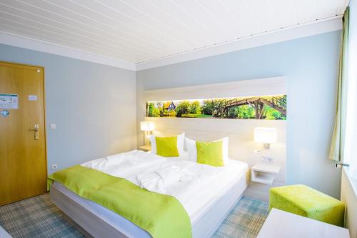 a white bedroom with a large bed and a window at Ferien Hotel Spree-Neisse in Neuhausen