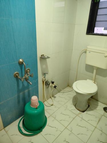 a small bathroom with a toilet and a shower at S Sai Inn in Shirdi