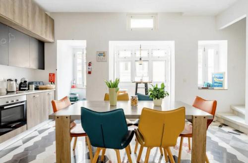 uma cozinha com uma mesa de jantar e cadeiras em Hammock Vibes Town House em Sliema