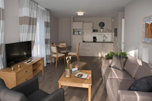 een woonkamer met een bank en een tafel bij Résidence Services Seniors DOMITYS - Villa Ulma in Lille