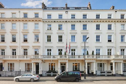 a large white building with cars parked in front of it at Eccleston Square Hotel in London