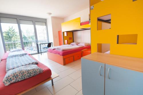a bedroom with two beds and a yellow wall at Simbol Rooms with free private parking in Ljubljana