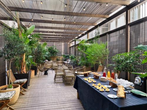 バルセロナにあるブティック ホテル H10 カタルーニャ プラザのパティオ(テーブル、椅子、植物付)