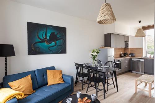 un salon avec un canapé bleu et une table dans l'établissement Le Poulpe - Proche plage de Rochebonne, à Saint-Malo