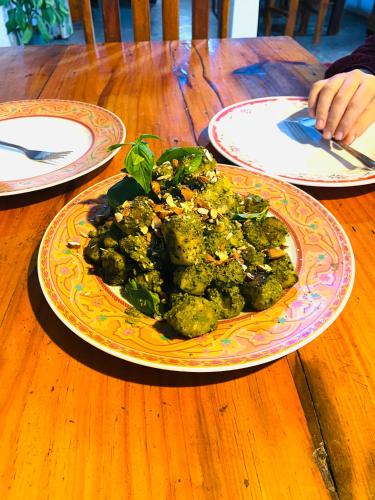 a plate of broccoli on a wooden table at Tropicana Home Stay in Arugam Bay