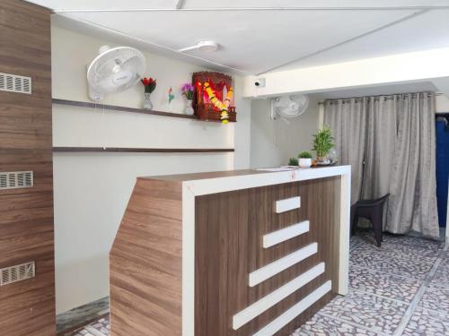 a kitchen with white walls and a wooden counter top at Hotel Orchid House Navi Mumbai in Navi Mumbai