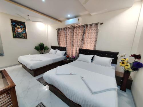 ナビムンバイにあるHotel Orchid House Navi Mumbaiのベッド2台と窓が備わるホテルルームです。