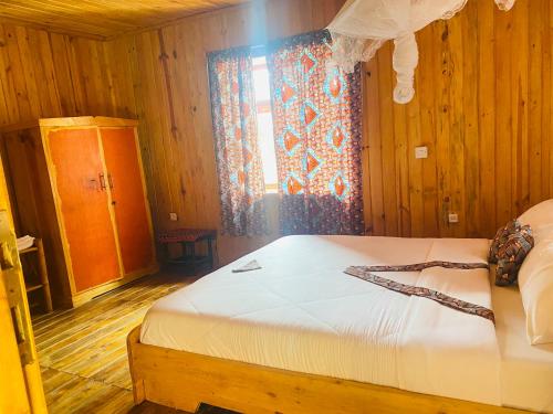 a bedroom with a bed in a room with a window at Kivu Macheo eco-lodge in Kibuye
