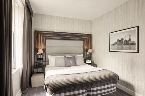 a bedroom with a large bed and a window at Eccleston Square Hotel in London