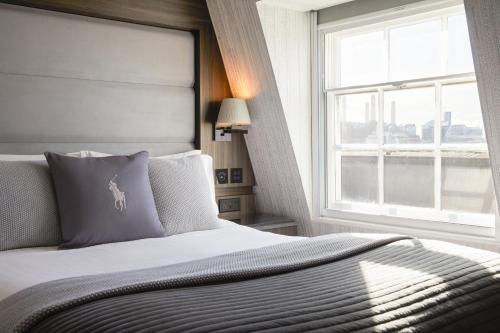 a bedroom with a large bed with a window at Eccleston Square Hotel in London