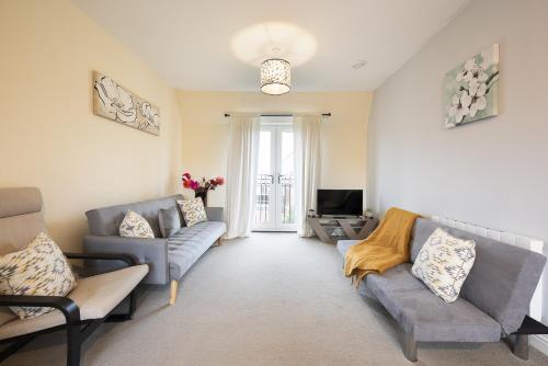 a living room with two couches and a television at Inaras place in Aylesbury