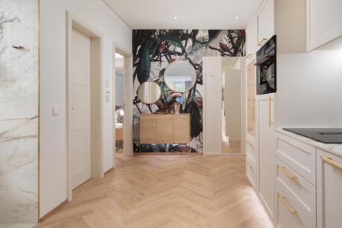 a kitchen with white cabinets and a mirror at SCHLOSSRESIDENZ - Boutique Apartments & Hotel Suiten in Schloß Ricklingen