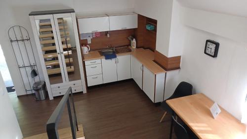 una pequeña cocina con armarios blancos y una mesa de madera. en Apartmány Orlová - ubytování v soukromí, en Orlová