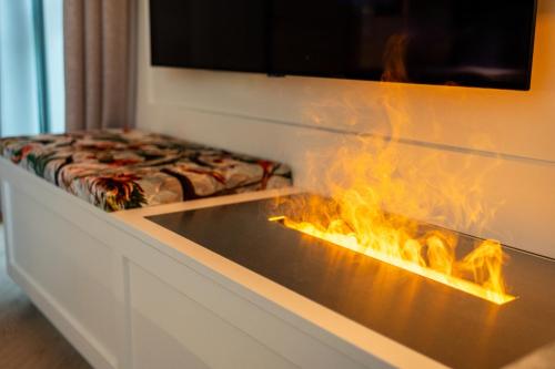 a fireplace with a stove with flames in it at SCHLOSSRESIDENZ - Boutique Apartments & Hotel Suiten in Schloß Ricklingen