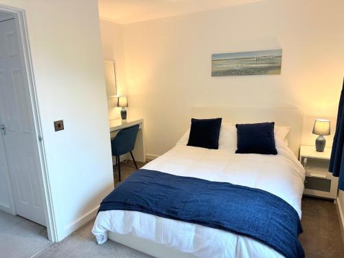 1 dormitorio con 1 cama blanca grande con almohadas azules en Fabulous 2 bed Town house free parking WiFI, en Derby