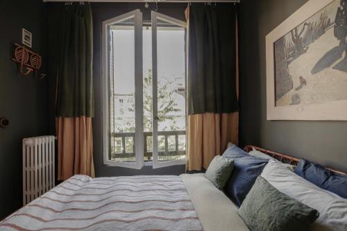1 dormitorio con cama y ventana grande en MAISON MOUZ, en París