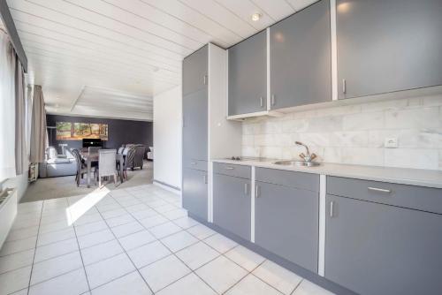a kitchen with blue cabinets and a dining room at Fletcher Hotel-Restaurant Waalwijk in Waalwijk