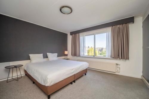 a bedroom with a large bed and a window at Fletcher Hotel-Restaurant Waalwijk in Waalwijk