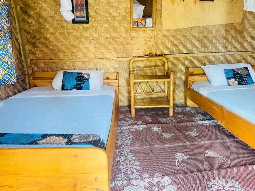 a room with two beds and a chair in it at Kivu Macheo eco-lodge in Kibuye