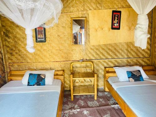 a room with two beds and two chairs in it at Kivu Macheo eco-lodge in Kibuye