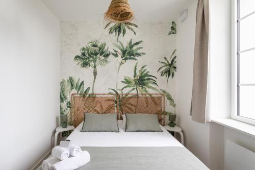 - une chambre avec un lit recouvert de palmiers dans l'établissement Le Coup de Soleil - Proche Plage de Rochebonne, à Saint-Malo