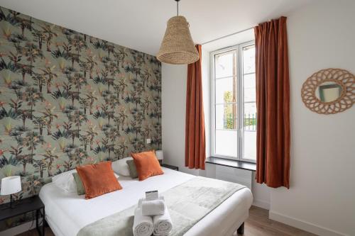 ein Schlafzimmer mit einem Bett mit Blumentapete in der Unterkunft Le Cargo - A 300m de la plage de Rochebonne in Saint-Malo