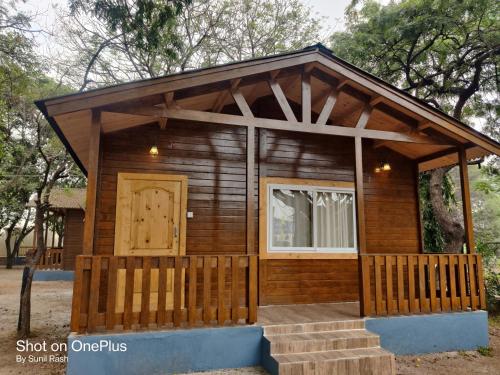a tiny house with a porch and a door at KSTDC Hotel Mayura Bhuvaneshwari Kamalapur in Hampi