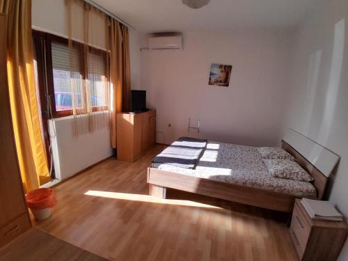 Schlafzimmer mit einem Bett und Holzboden in der Unterkunft Airport ROOMS NIKKI in Belgrad