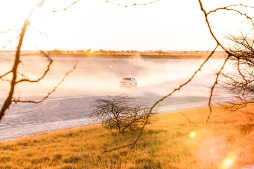 a car driving on a flooded road near water at Nata Lodge in Nata