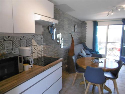 une cuisine avec une table et une salle à manger dans l'établissement Maisonnette 2 pièces 4 personnes à 200 m de la plage - GURVAL, à Sarzeau