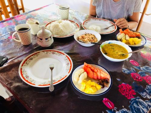 uma mesa cheia de pratos de comida numa mesa em Tropicana Home Stay em Arugam Bay