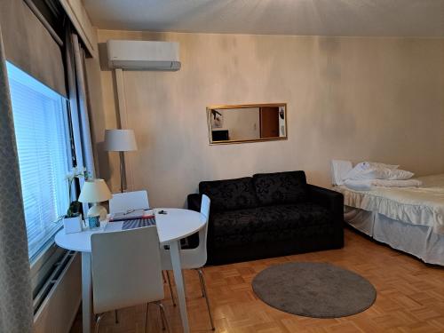 een kleine woonkamer met een bank en een tafel bij Saunallinen yksiö in Pieksamaki
