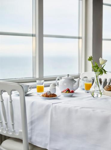 a table with a white table cloth and a tea set at Grand Hôtel Mölle in Mölle