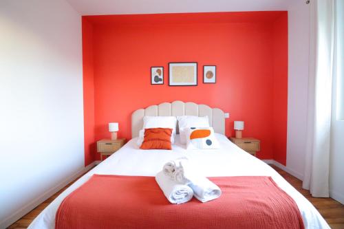 Dormitorio rojo con cama blanca y paredes rojas en Le Boho - Charmant T3 - gare à 5 min à pieds en Bergerac