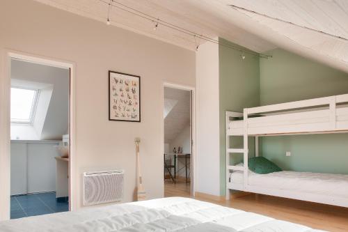 une chambre avec deux lits superposés et un bureau dans l'établissement Jardin et piscine - 1km de la plage de Mousterlin, à Fouesnant