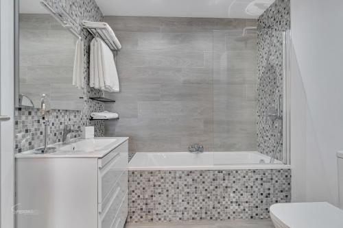 La salle de bains blanche est pourvue d'une baignoire et d'un lavabo. dans l'établissement Vista Castillo - By Aldertons, à Moraira
