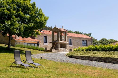 two chairs sitting in the grass in front of a house at Landras de Compostela in Santiago de Compostela