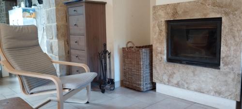 a living room with a chair and a fireplace at MUNTTEIGOIKO in Legazpia