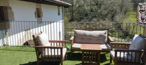 two chairs sitting on a balcony with a fence at MUNTTEIGOIKO in Legazpia