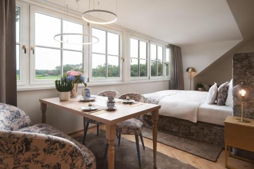a hotel room with a bed and a table and chairs at SCHLOSSRESIDENZ - Boutique Apartments & Hotel Suiten in Schloß Ricklingen